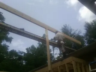 Carpenter setting a ridge beam over a new addition frame — Ice Dam Removal by Roofing Brothers in Oakmont