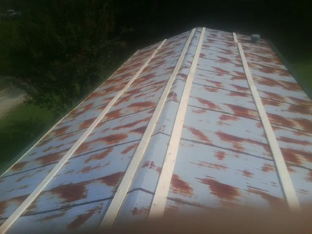 Rusted metal roof panels with new wood purlins before replacement — Storm Damage Roof Repair in Oakmont by Roofing Brothers