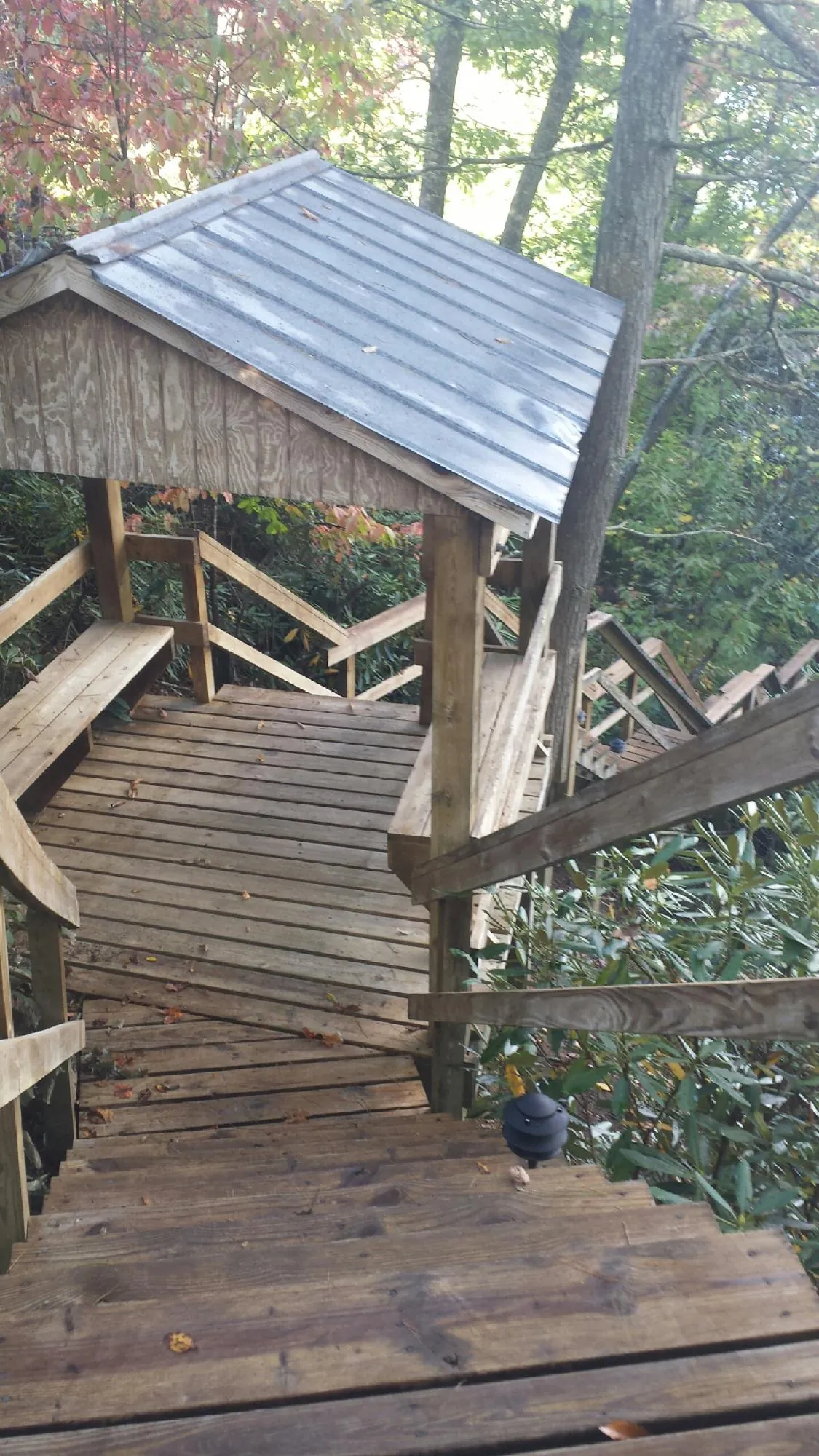 Metal roofed shelter over wooden steps on a wooded walkway — Skylight Repair & Installation work by our crew in Oakmont