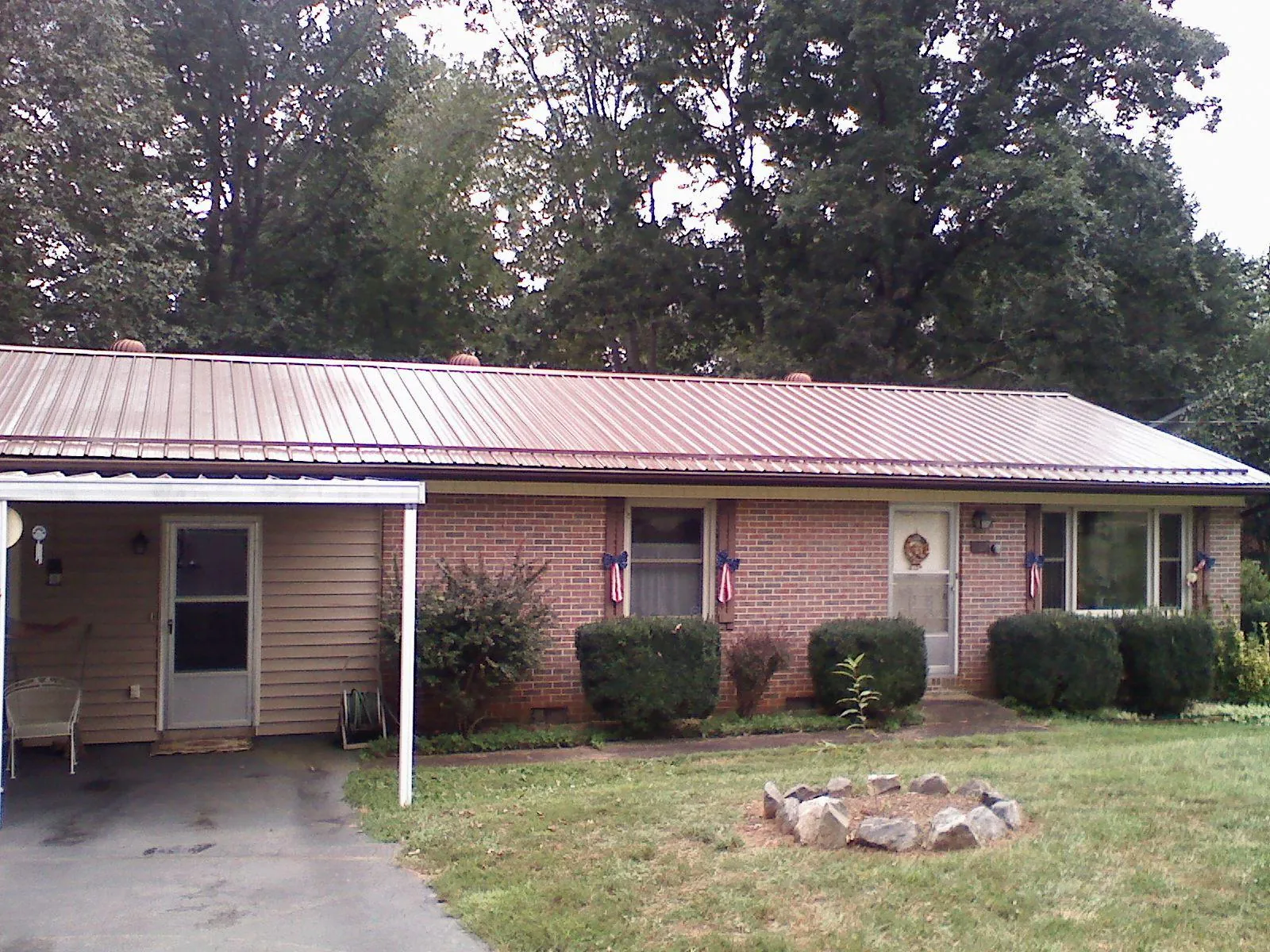 Bronze metal roof and carport on a brick ranch home — Roof Repair work by our crew in Oakmont